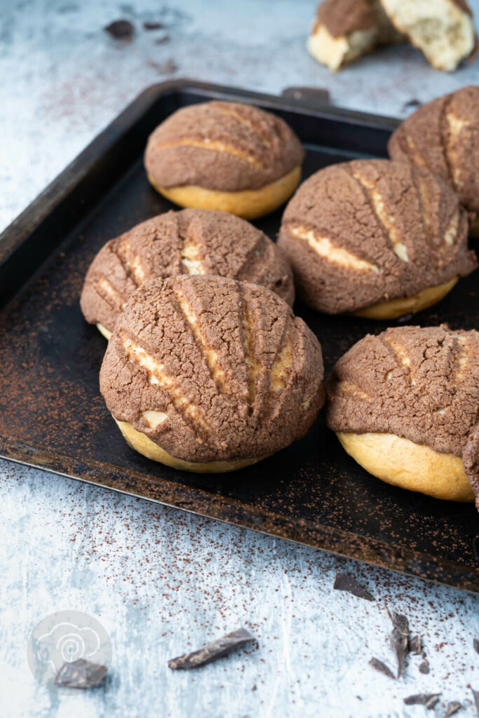 Mexikanische Conchas 3 Mexikanische Conchas auf einem Blech mit Schokostückchen.